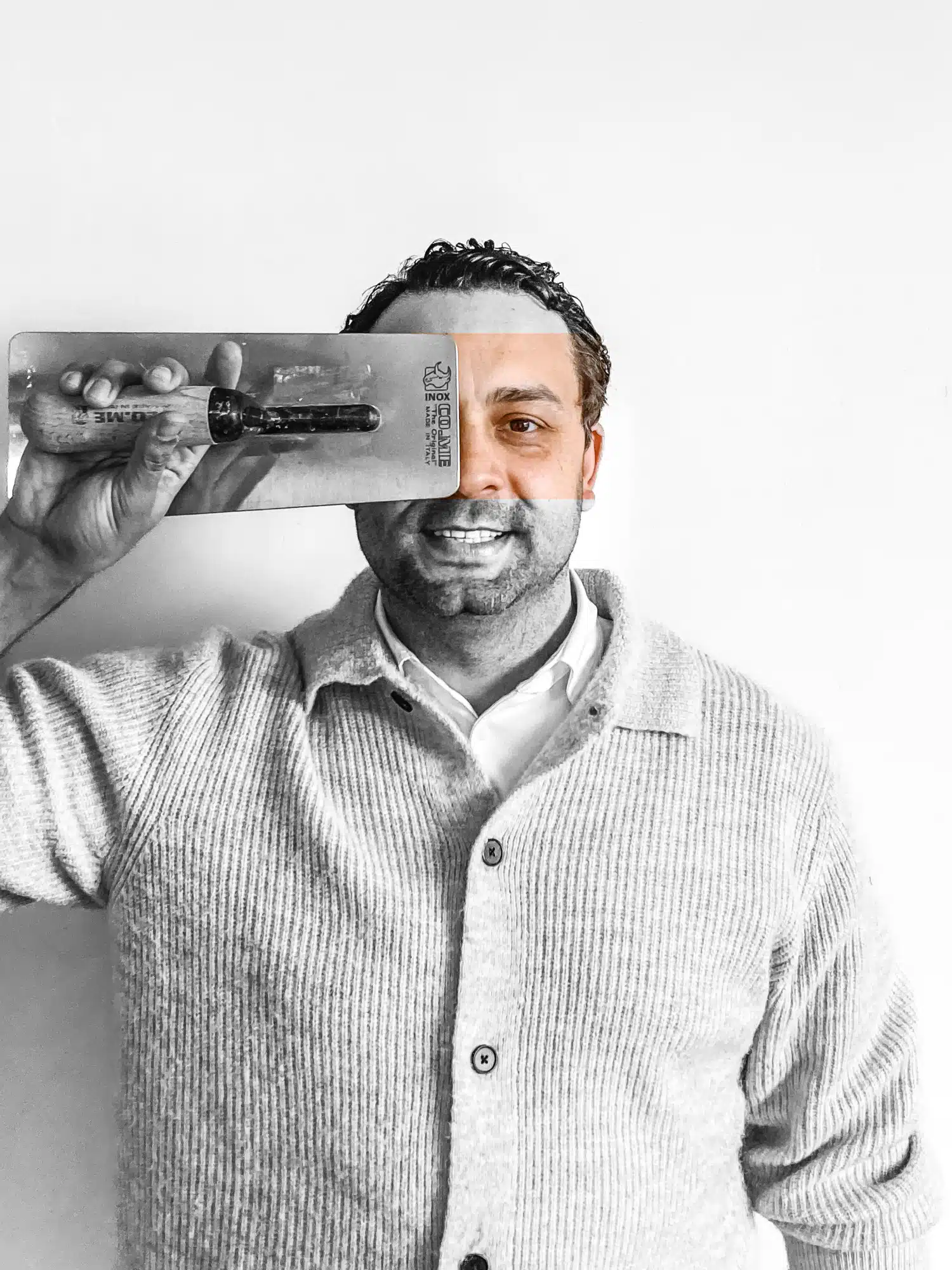 Professionele pleisterwerker van In't Wit met gereedschap, glimlachend in zwart-wit portret
